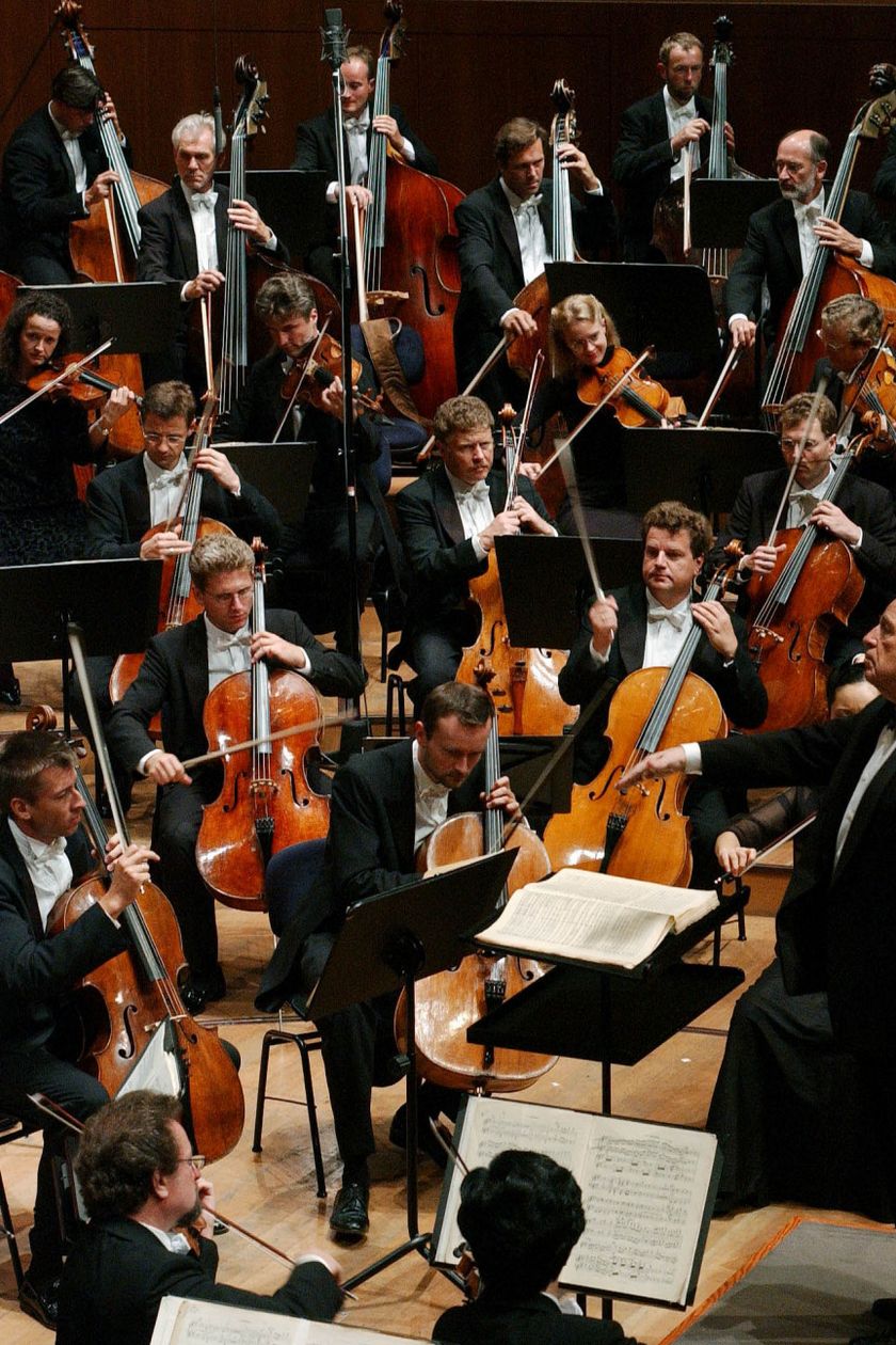 Ein Sinfonieorchester mit Dirigent spielt auf einer Bühne im Konzertsaal.
