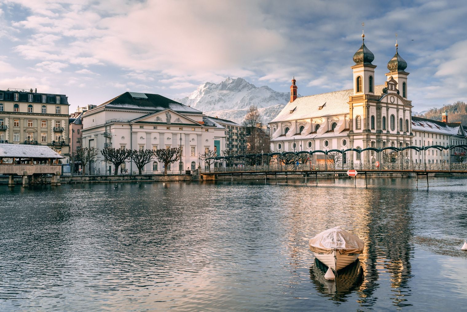 Luzerns Altstadt und der See im Winter mit sanfter Schneedecke und klarer Bergsicht – eine ruhige, winterliche Stadtlandschaft.
