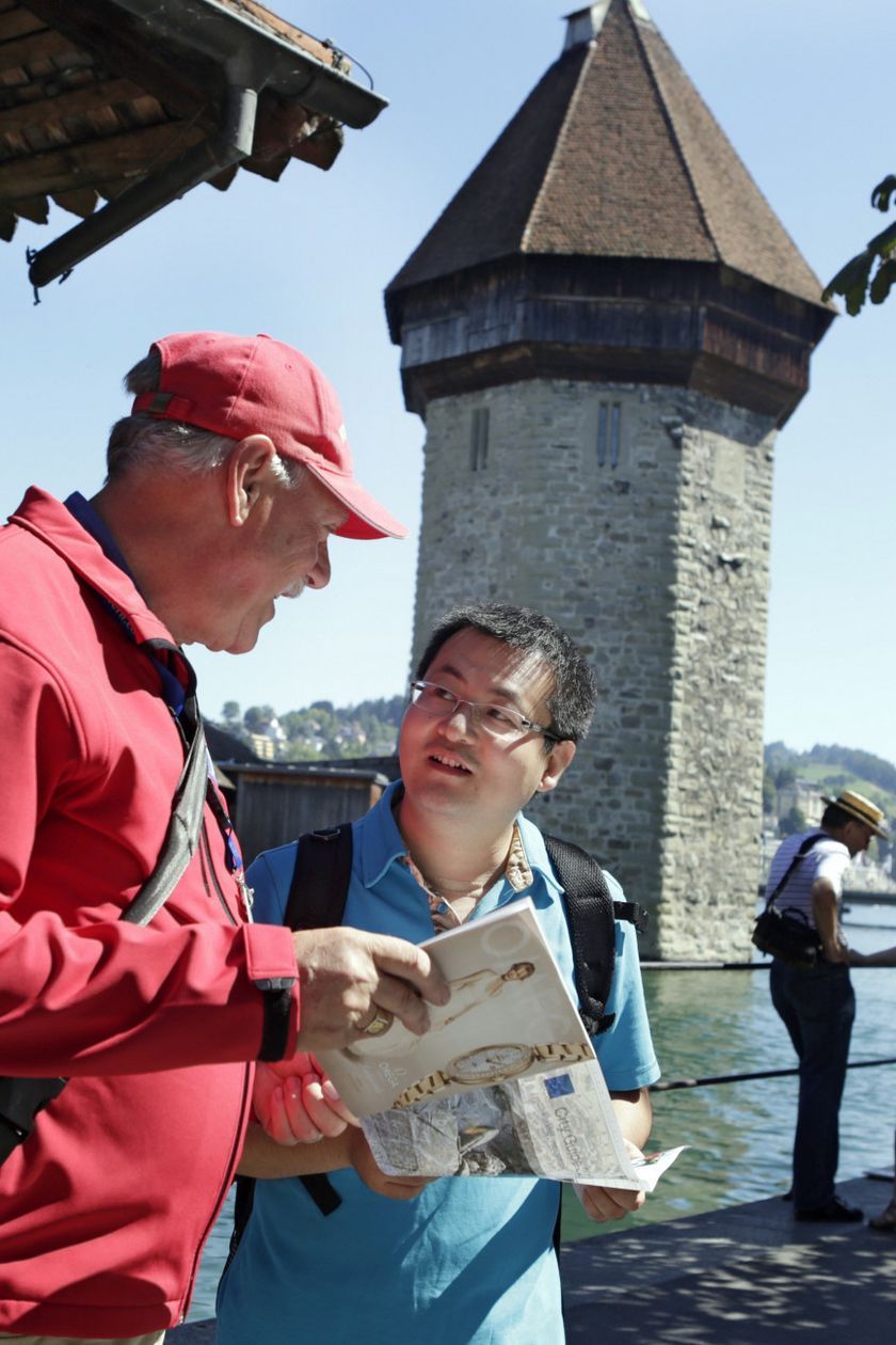 Stadtführer erklärt einem Gast die Kapellbrücke in Luzern