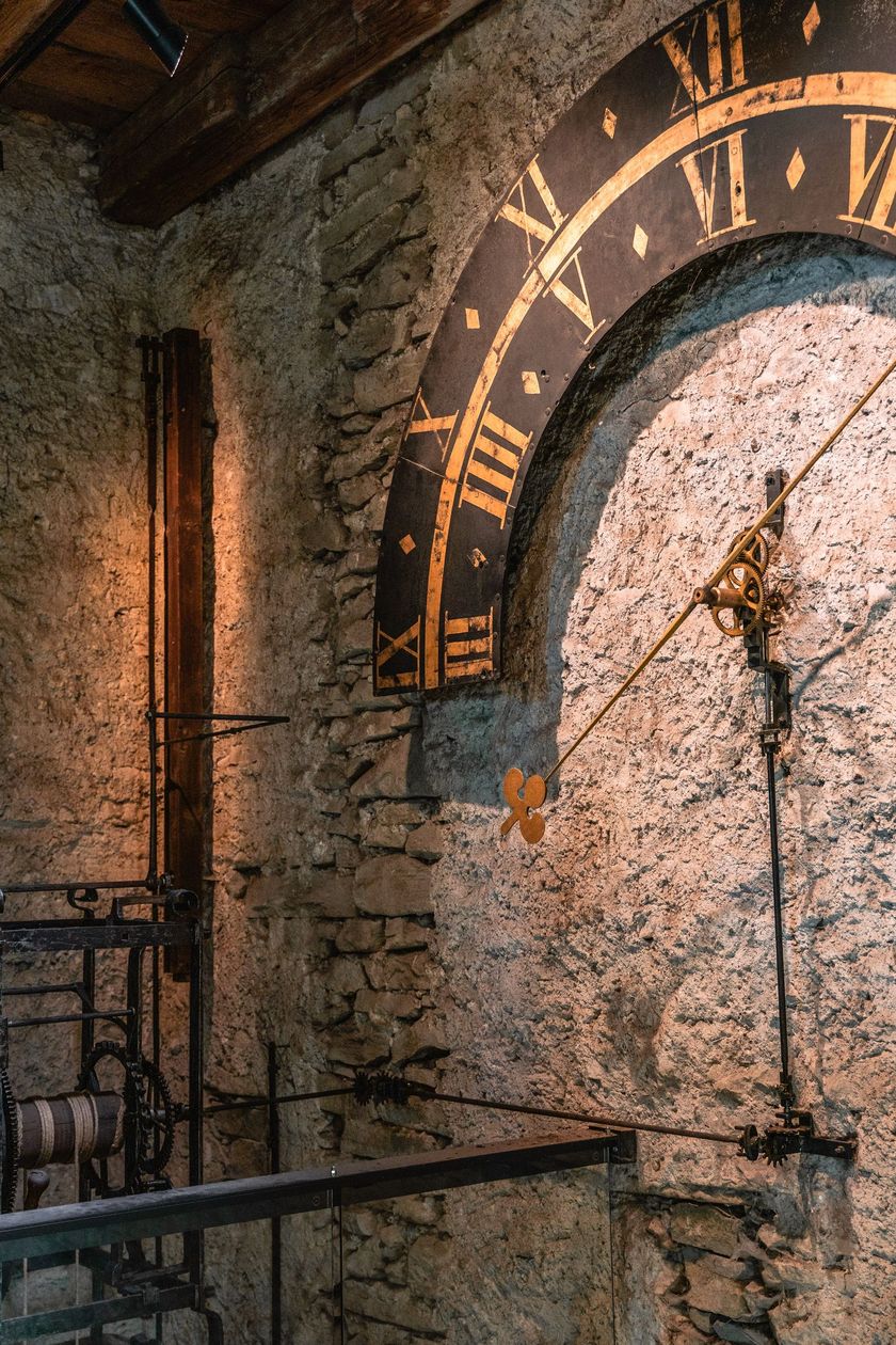 Innenansicht des Zytturms der Museggmauer in Luzern mit historischem Uhrwerk, goldfarbenem Zifferblatt mit römischen Ziffern und mittelalterlichem Steinmauerwerk