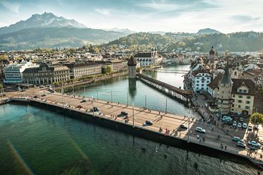 Panorama von Luzern mit Altstadt, Seeufer, und dem Pilatus im Hintergrund bei klarem Wetter.
