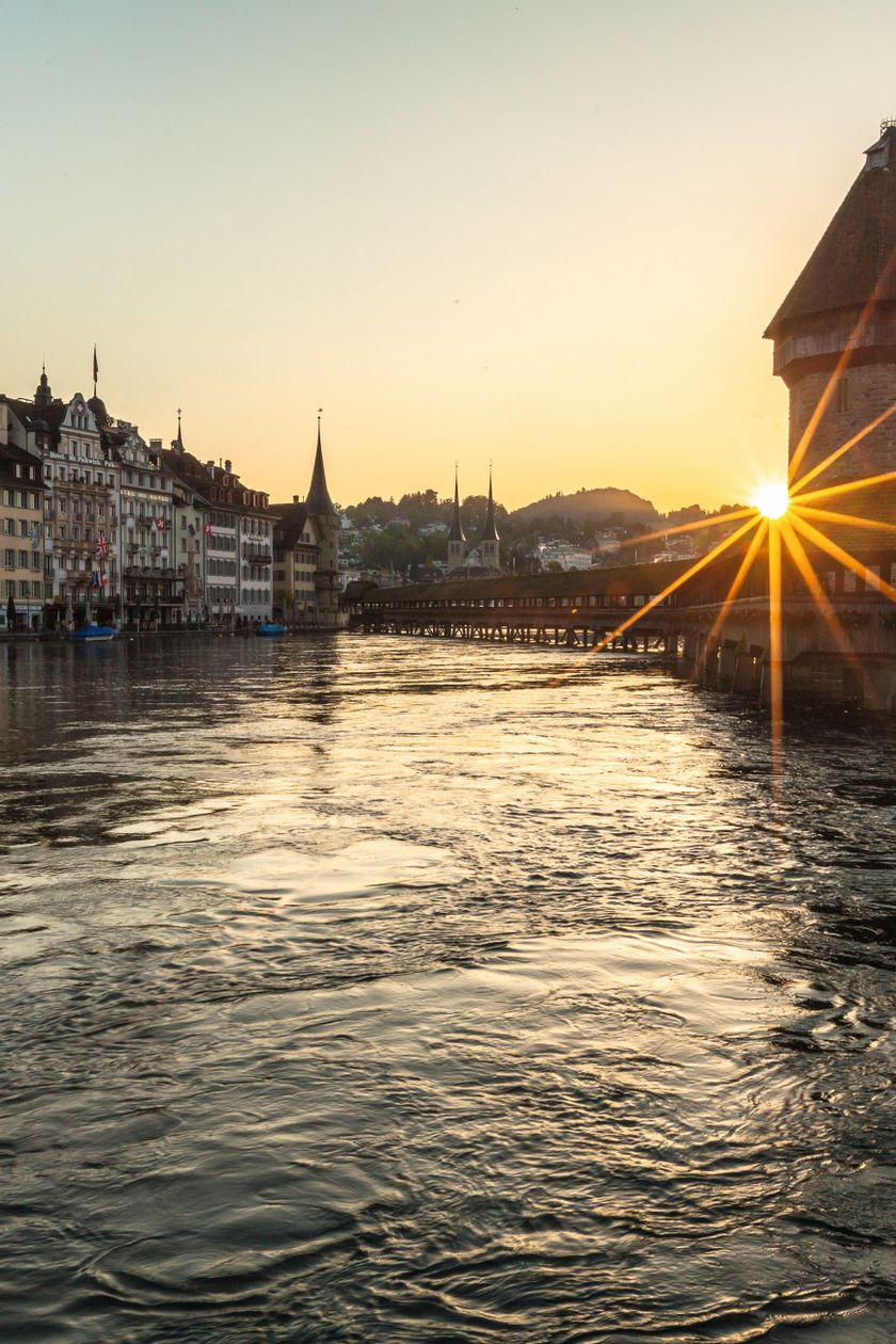Kapellbrücke mit Wasserturm in Luzern bei Sonnenaufgang über der Reuss
