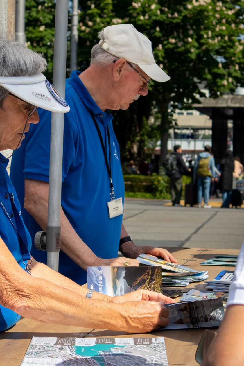 Friendly Hosts beraten Gäste an einem Infostand in Luzern